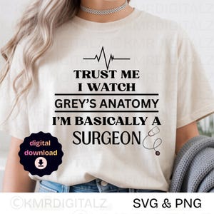 May include: Beige t-shirt with the text "TRUST ME I WATCH GREY'S ANATOMY I'M BASICALLY A SURGEON" in black. A heartbeat line and stethoscope graphic are included. A digital download icon is in the lower left.