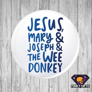 May include: White button with blue text that reads "JESUS, MARY & JOSEPH & THE WEE DONKEY".