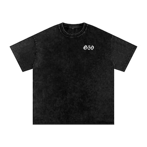 Puede incluir: Camiseta negra de gran tamaño con un aspecto vintage descolorido. La camiseta presenta el número "659" en blanco, con una fuente gótica en la parte superior del pecho. Cuello redondo y mangas cortas, ideal para uso casual.