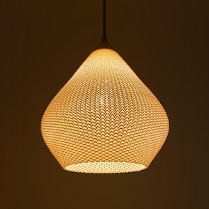 May include: A hanging pendant light with a textured, woven shade. The shade is a warm, off-white color and has a teardrop shape. The light is suspended from a dark cord against a dark brown background.