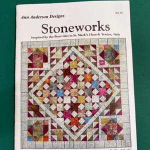 May include: A printed pattern for a quilt titled "Stoneworks" by Ann Anderson Designs. The design is inspired by floor tiles in St. Mark's Church, Venice, Italy. The pattern includes instructions for a wall quilt, table topper, bed quilt, table runner, and placemats. Bed size is 94" x 94".