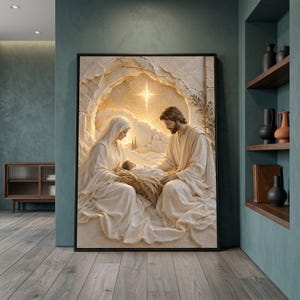 Könnte beinhalten: Ein gerahmter Wandkunstdruck, der eine Krippenszene zeigt, mit zwei Figuren in fließenden cremefarbenen Gewändern, die zusammensitzen und ein Neugeborenes wiegen. Ein heller, leuchtender Stern strahlt im Hintergrund über einer Steinhöhle.
