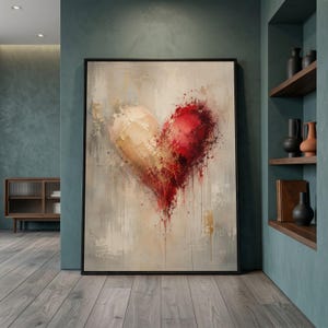 Può includere: Un'opera d'arte murale rettangolare incorniciata che presenta una forma di cuore astratta. Il lato sinistro del cuore è di un colore crema tenue, mentre il lato destro sfuma in un rosso vibrante con schizzi e gocciolamenti di vernice su fondo beige.