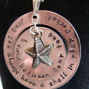 May include: Silver necklace with a double-sided pendant. The outer circle reads "Always have a shell in your pocket". The inner circle reads "and sand between your toes". A silver starfish charm hangs from the pendant.