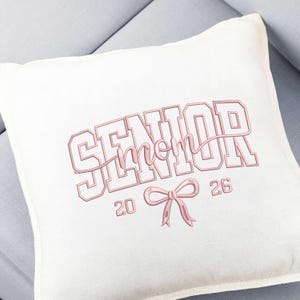 Puede incluir: Una taza de cerámica blanca con un asa negra y el texto "But First, Coffee" en un estilo manuscrito. La taza está sobre una superficie blanca. La taza mide aproximadamente 10 cm de alto.