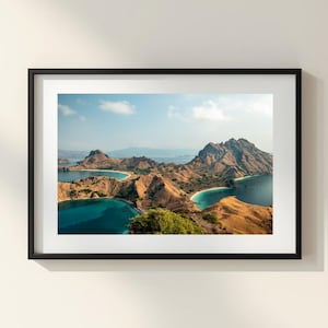 Può includere: Una stampa paesaggistica incorniciata con una vista panoramica di isole e acque turchesi. La fotografia cattura la bellezza naturale delle montagne, del mare e del cielo, con una cornice nera.