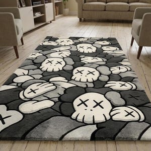 May include: A rectangular area rug featuring a repeating pattern of white skulls with black X-shaped eyes and gloved hands against a background of various shades of gray and black. The design is composed of multiple overlapping cartoon-style figures.