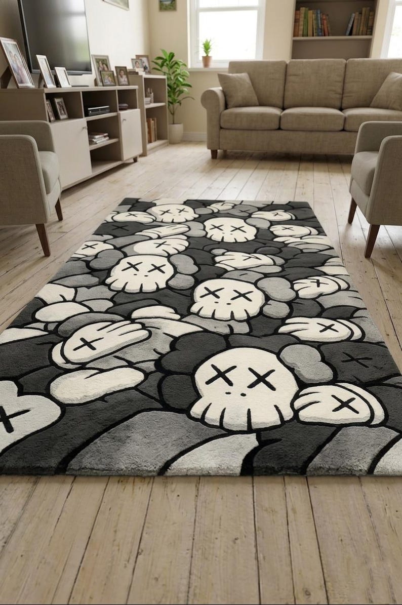 May include: A rectangular area rug featuring a repeating pattern of white skulls with black X-shaped eyes and gloved hands against a background of various shades of gray and black. The design is composed of multiple overlapping cartoon-style figures.