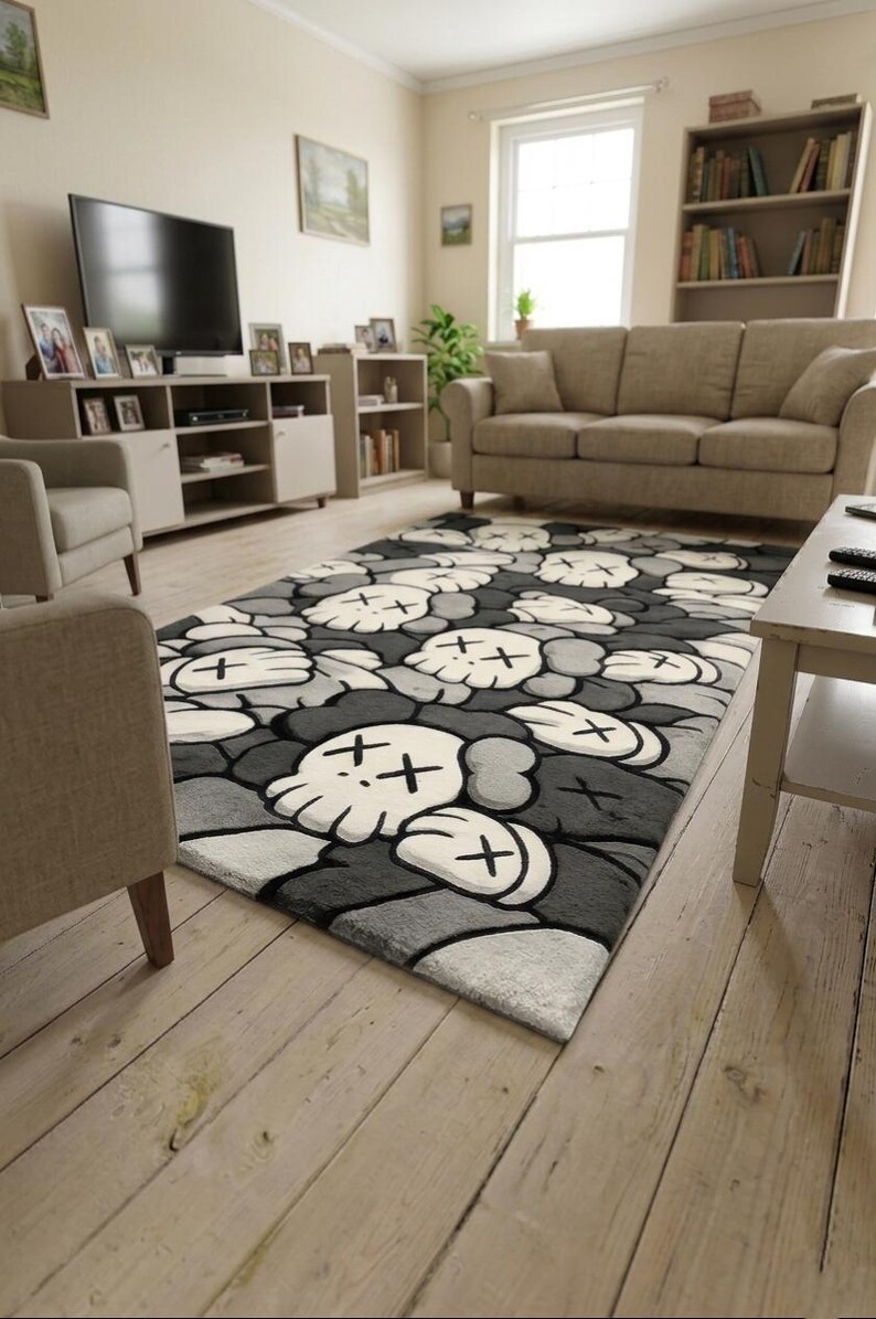 May include: A rectangular area rug featuring a repeating pattern of stylized skull-like figures with cross-shaped eyes. The design uses a monochromatic color palette of black, dark gray, light gray, and white, creating a dense, layered graphic effect.
