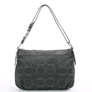 May include: Black shoulder bag with a repeating pattern of interlocking "C" shapes. The bag has a leather top and a silver zipper. The straps are thin and black. The bag is a medium size.