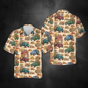 May include: A short-sleeved button-down shirt in a light beige color featuring an all-over print of vintage trucks, red barns, pumpkins, and hay bales. The shirt has a classic collar, a front button placket, and a straight hemline design.