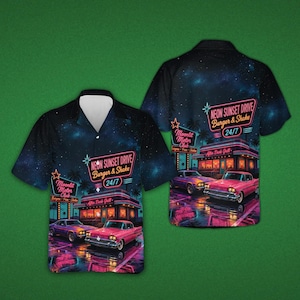 Puede incluir: Una camisa de manga corta con botones y un estampado de cielo nocturno estrellado en azul oscuro. El diseño muestra un restaurante retro con las etiquetas Neon Sunset Drive Burger & Shake 24/7, Moonlit Motor Club y After Dark Grill, con dos coches rosas.