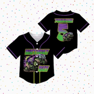 May include: Black baseball jersey with purple and green detailing. The front displays "BIRTHDAY BOY" and a monster truck graphic. The back has the number "5" and "YOURNAME", with a matching monster truck graphic.