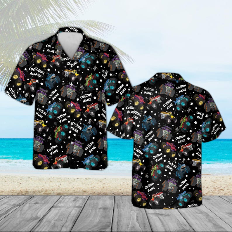 May include: Black button-down shirt with a repeating pattern of colorful monster trucks, stars, and the text "CUSTOM NAME". The short-sleeved shirt is displayed on a beach background.