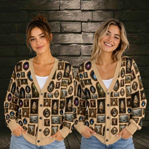 May include: A beige V-neck cardigan featuring an all-over print of various framed portraits of ghosts and spooky scenes. The button-down sweater has long sleeves with ribbed cuffs and a matching ribbed hem, showcasing a repeating gallery wall pattern.