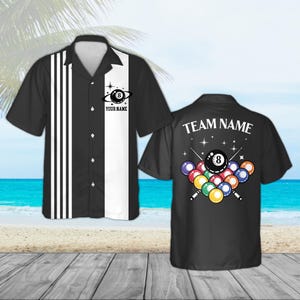 May include: Black and white short-sleeved button-down shirt with a bowling theme. The front features a black panel with white stripes and the text "YOUR NAME". The back displays a pool ball graphic and the text "TEAM NAME".