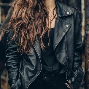 Könnte beinhalten: Schwarze Lederjacke mit asymmetrischem Reißverschluss und Druckknopfdetails. Die Jacke hat einen klassischen Biker-Stil mit Reverskragen und langen Ärmeln. Das Model trägt ein schwarzes Oberteil und eine schwarze Hose.