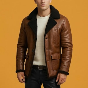 May include: A brown leather jacket featuring a black faux fur collar and interior lining, long sleeves, a button-front closure, and two front flap pockets. The jacket is worn over a white textured sweater and black trousers with a brown belt.