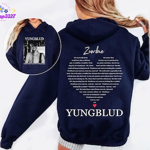 May include: Navy blue hoodie featuring a black and white image of a singer with the text "YUNGBLUD" and "I know that I can't live without you." The back displays the song lyrics "Zombie" and the artist's name.