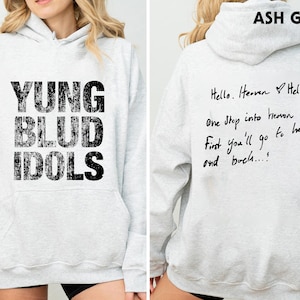 May include: Ash grey hoodie with the text "YUNG BLUD IDOLS" on the front. The back of the hoodie has handwritten text that reads "Hello. Heaven Hello. One Stop into Heaven. First you'll go to hell and buch...!"