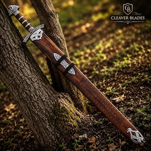 May include: A sword with a brown wooden hilt and scabbard, featuring intricate silver-colored metal accents and knotwork engravings. The scabbard displays a dark wood grain with a woven pattern, and the text CLEAVER BLADES is visible.