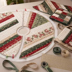 May include: A circular quilted tree skirt featuring alternating strips of red, green, and cream fabric with poinsettia and star patterns. The skirt has a center cutout and is held by red clips. Nearby are folded fabric pieces, ribbon, and a rotary cutter.
