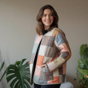 May include: A patchwork quilted jacket in shades of peach, blue, tan, and grey. The jacket has a collarless design and two front pockets. The model is wearing a black top underneath.