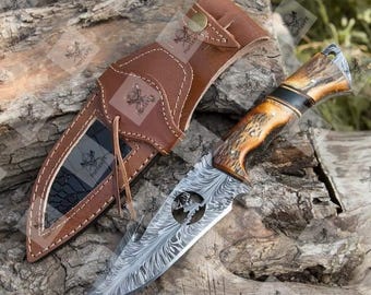 Cuchillo desollador de acero de Damasco forjado a mano con plumas, mango de ciervo y gancho para destripar.