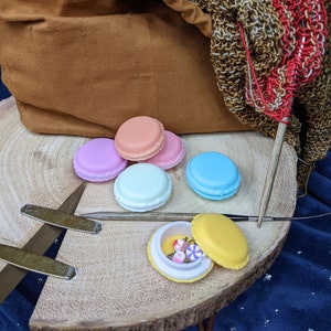 May include: A wooden tray with a brown canvas bag, a knitting needle, and several small colorful macaron-shaped containers. The containers are open and filled with colorful beads and buttons.