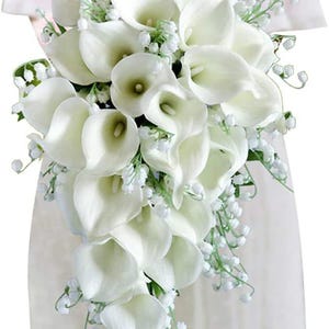 Puede incluir: Un ramo de novia en cascada con calas blancas y delicado lirio de los valles. El arreglo se acentúa con follaje verde, creando una exhibición floral clásica y elegante.