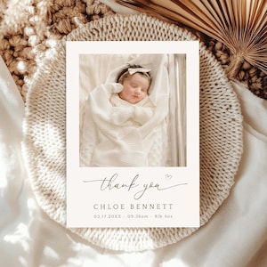 Könnte beinhalten: Eine cremefarbene Karte mit einem Babyfoto, umgeben von einer gewebten Textur. Auf der Karte steht "Danke" in Schreibschrift, mit dem Namen des Babys, dem Geburtsdatum, der Uhrzeit und dem Gewicht (3,7 kg) darunter. Das Baby ist in eine weiße Decke gehüllt.