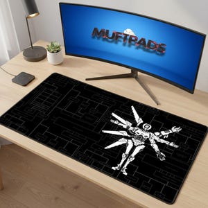 Peut inclure: Tapis de bureau rectangulaire noir avec un motif de robot blanc et un motif schématique. Le tapis est sur un bureau en bois, avec un écran d'ordinateur affichant "MUFTPADS". Une petite plante et une lampe de bureau sont également visibles.