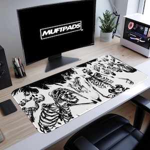Puede incluir: Alfombrilla de ratón rectangular blanca con un diseño de esqueleto en blanco y negro. La alfombrilla tiene el texto "MUFTPADS" en un cuadro blanco en la pantalla del ordenador. El diseño presenta múltiples esqueletos.