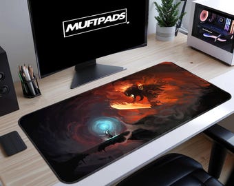 May include: A large rectangular desk mat featuring a fantasy art scene with a dragon and a figure with a glowing orb. The mat has a black border and the text "MUFTPADS" on the monitor in the background.