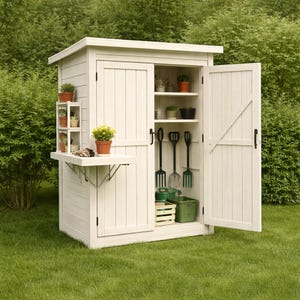 May include: A white wooden garden shed with an open door, revealing shelves with potted plants and gardening tools. A small fold-down table and additional shelves hold more plants. The shed is set on a green lawn.