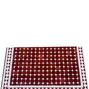 May include: A rectangular tile table top featuring a repeating pattern of dark red squares. The border is white with a diamond pattern, and a black edge. Suitable for indoor or outdoor use, this table top is a decorative piece.