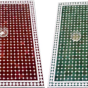 May include: Two rectangular mosaic tables, one in deep red and the other in emerald green. Each table has a grid pattern of small, square tiles and a white border with triangles. A small glass bowl sits on each table.