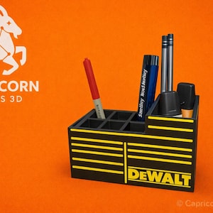 May include: A black and yellow pen holder with the word "DEWALT" on the front. The pen holder is divided into multiple compartments and contains pens and markers. The background is orange, and the logo "Capricorn Prints 3D" is in the upper left corner.