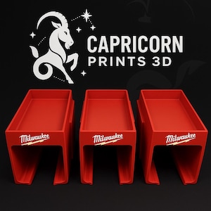 Può includere: Tre vassoi espositivi rossi stampati in 3D con il logo Milwaukee in bianco. I vassoi sono rettangolari con un profilo basso e piani aperti. Il testo "CAPRICORN PRINTS 3D" è sopra i vassoi, insieme a un simbolo bianco del Capricorno.