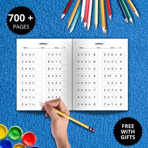 Könnte beinhalten: Offenes Arbeitsbuch mit Additionsaufgaben, eine Hand mit Bleistift und Buntstifte auf blauem Hintergrund. Das Arbeitsbuch hat den Text "700+ PAGES" und "FREE WITH GIFTS".