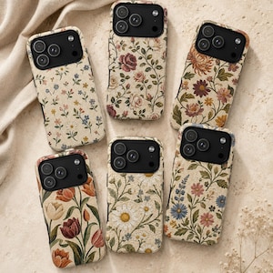 Könnte beinhalten: Sechs rechteckige Smartphone-Hüllen mit verschiedenen Blumenmustern auf einer beigen, stoffartigen Textur. Jede Hülle hat einen schwarzen Kameraausschnitt mit drei runden Linsen und einem Blitz. Die Designs zeigen Rosen, Gänseblümchen und Tulpen.