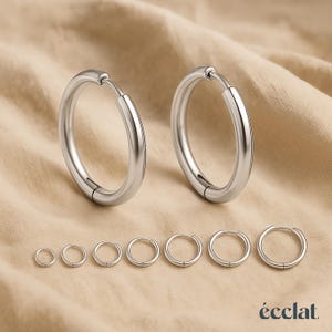 Peut inclure: Ensemble de boucles d'oreilles créoles argentées de différentes tailles. L'image présente deux grandes créoles et six plus petites. Les boucles d'oreilles sont en métal brillant et sont présentées sur un fond neutre.