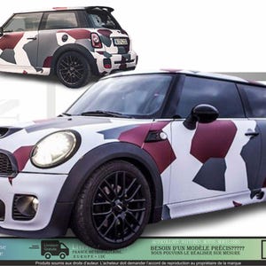 Könnte beinhalten: Ein Mini Cooper mit einem Tarnmuster in Weiß, Grau und Burgunderrot. Das Auto hat schwarze Räder und einen schwarzen Spoiler. Das Bild zeigt das Auto von vorne und von der Seite sowie von hinten und von der Seite.