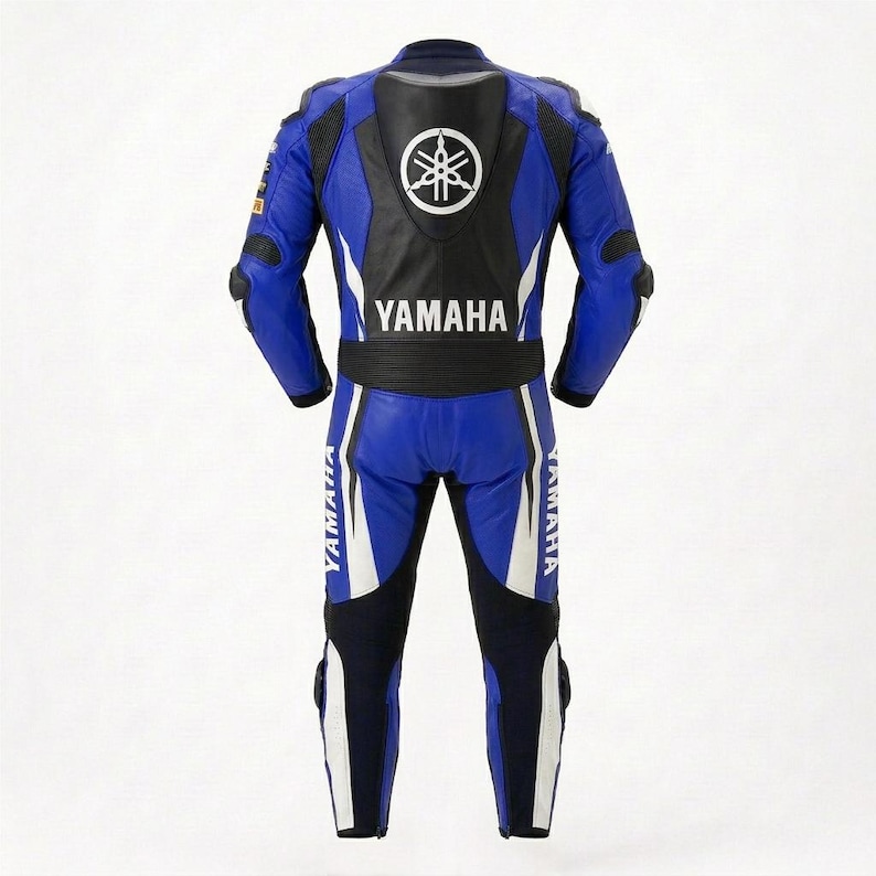 May include: A blue, black, and white leather motorcycle racing suit featuring the Yamaha logo and text on the back. The suit includes a protective back hump, articulated joints at the elbows and knees, and white accents along the legs and torso.