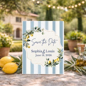 May include: A Save the Date card with blue and white stripes, featuring a floral lemon design and the names Sophia & Louis, with the date June 18, 2026. Two lemons and a bottle of olive oil are in the foreground.