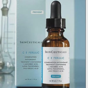 May include: A brown glass bottle with a black dropper and a white label, next to a light blue box. The label reads "SkinCeuticals C E Ferulic" and "Combination Antioxidant Treatment". The box also has the text "Prevent". The bottle contains 30 ml.