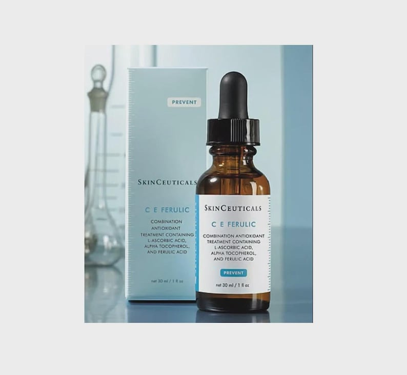 May include: A brown glass bottle with a black dropper and a white label, next to a light blue box. The label reads "SkinCeuticals C E Ferulic" and "Combination Antioxidant Treatment". The box also has the text "Prevent". The bottle contains 30 ml.