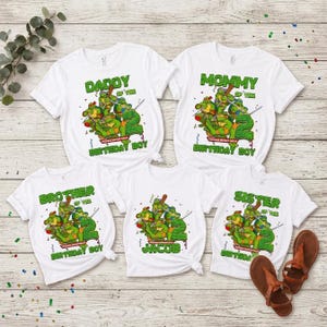 May include: Five white t-shirts featuring Teenage Mutant Ninja Turtles graphics and the number 2. The shirts include text labels: DADDY OF THE BIRTHDAY BOY, MOMMY OF THE BIRTHDAY BOY, BROTHER OF THE BIRTHDAY BOY, JACOB, and SISTER OF THE BIRTHDAY BOY.