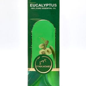 May include: A green box of eucalyptus essential oil, with the text "EUCALYPTUS 100% PURE ESSENTIAL OIL" and "30 ml". The box features a gold-coloured circular logo with the text "SYAM HOMES". The box has a green and white design.