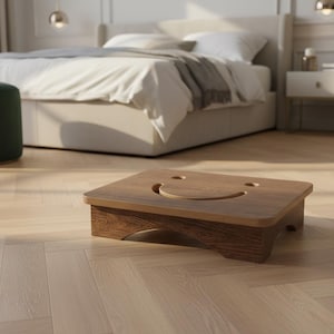 May include: A wooden step stool with a smiling face cutout on the top surface. The stool is made of dark brown wood with a lighter brown border. The stool is designed for use in a bedroom setting.